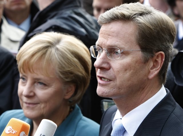 The chairwoman of the German Christian Democratic Party (CDU), Angela Merkel, left, and the chairman of the German Liberals, Guido Westerwelle, right, talk to journalists as part of the negotiations of the three parties, for a new ruling coalition in Berlin, Monday, Oct. 5, 2009. (AP Photo/Michael Sohn)