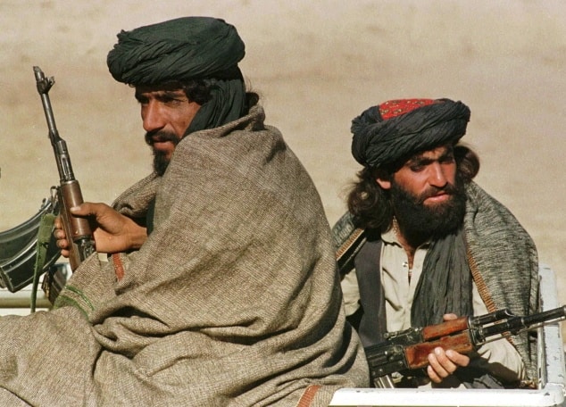 Taliban - bojovník, bojovníci - zbraň, samopal FILE -- Two Taliban fighters sit in the back of their vehicle some 20 kilometers (13 miles) north of Kabul October 26, 1996. Diplomats and the United Nations lobbied Wednesday Aug. 8, 2001, for the release of imprisoned foreign aid workers, whom the ruling Taliban are investigating for allegedley preaching Christianity in this Muslim nation. (AP Photo/Santiago Lyon)