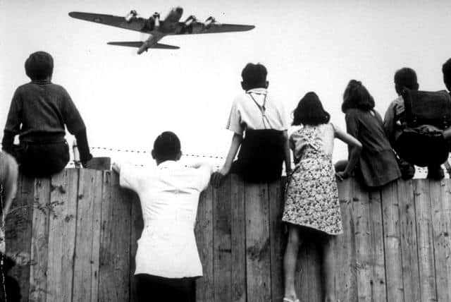 Děti sledují spojenecké zásobovací letadlo přistávající za sovětské blokády na berlínském letišti Tempelhof na archivním snímku z roku 1948. Vrchní správní soud v Berlíně zamítl 12. února žaloby několika leteckých společností, které žádaly pokračování leteckého provozu na tomto letišti, jež má být koncem října 2008 uzavřeno. Gigantický terminál s hangáry byl vybudován v letech 1936 až 1941 lidmi na nucených pracích během režimu Adolfa Hitlera.
