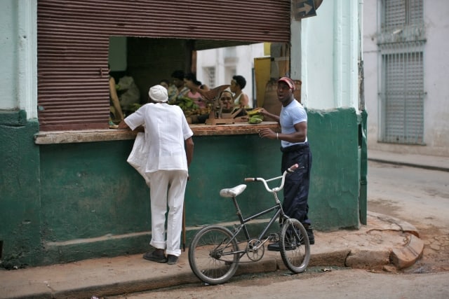 Two men stand at a fruit store in Havanna, Cuba, 18 September 2009. Photo: Fredrik von Erichsen