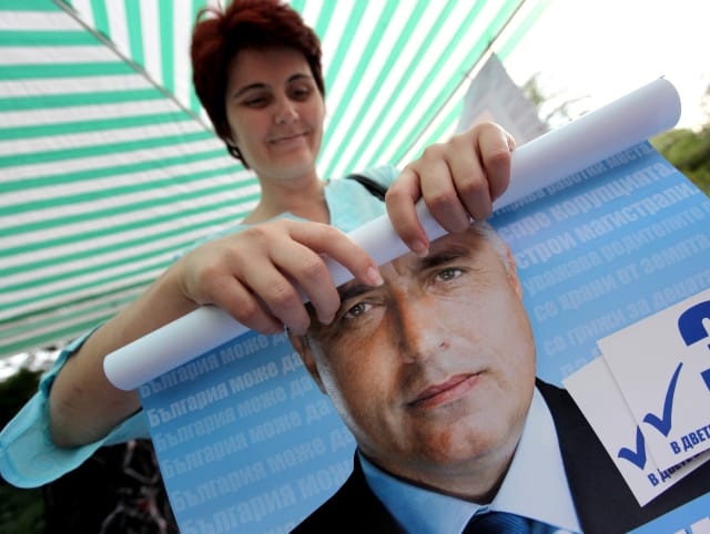A supporter rolls a poster with the picture of Bulgarian right-wing opposition GERB party leader Boiko Borisov in the Bulgarian capital Sofia, Saturday, July, 4, 2009. Opinion polls in the run-up to Sunday's vote have suggested Prime Minister Sergei Stanishev will pay the price for the failure of his corruption-tainted government to handle an economy hit hard by the global downturn. One poll published Saturday suggested his main opponent, the capital's Mayor Boiko Borisov would easily win. (AP Photo/Petar Petrov) =@=