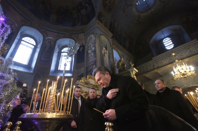 Ukrainian opposition leader and the Presidential candidate Viktor Yanukovych, foreground center, crosses himself in the Kyiv-Pechersk Lavra church in Kiev, Ukraine, Saturday, Jan. 16, 2010. In the final hours of the Ukraine's bitterly fought presidential campaign, candidates accused one another of planning to commit campaign fraud and experts warned of the possibility of post-election unrest. (AP Photo/Alexander Zemlianichenko)