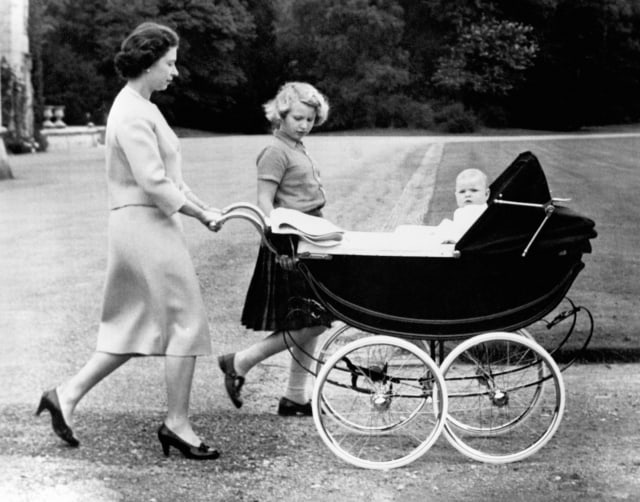 The Queen, accompanied by Princess Anne, pushes the pram of her younger son, Prince Andrew, during a walk in the grounds at Balmoral.