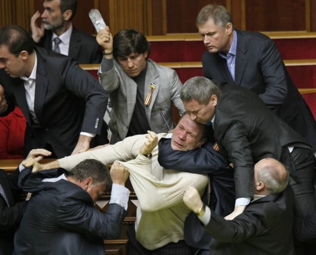 Ukrainian opposition and pro-presidential lawmakers fight against each other during ratification of the Black Sea Fleet deal with Russia, in parliament in Kiev, Ukraine, Tuesday, April 27, 2010. Ukraine's parliament has voted to extend Russia's lease of a Crimean naval port for the Black Sea Fleet in a chaotic session during which eggs and smoke bombs were thrown. The countries' presidents agreed last week to extend the Russian navy's use of the Sevastopol port for another 25 years after the old lease expires in 2017. (AP Photo/Efrem Lukatsky)