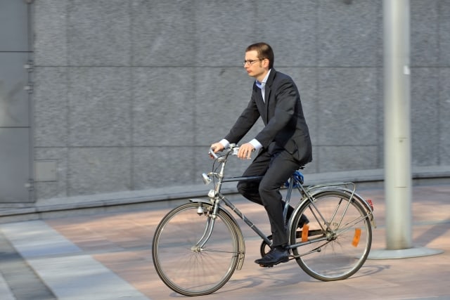 Mladý úředník projíždí na kole kolem budovy Evropského parlamentu. Foto: getphoto.cz/martin salajka