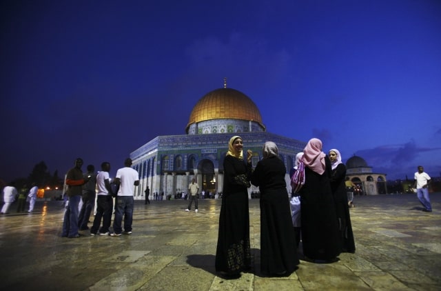 Muslims are seen next to the Dome of Rock Mosque during the first day of Eid al-Fitr, which marks the end of the Muslim fasting month of Ramadan, in the Al Aqsa Mosque Compound in Jerusalem's Old City, Sunday Sept. 20, 2009. Eid, one of the most important holidays in the Muslim world, is marked with family reunions and other festivities. (AP Photo/Muhammed Muheisen)