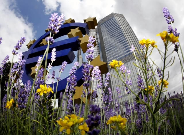 The Euro sculpture is seen between flowers in front of the European Central Bank ECB building in Frankfurt, central Germany, Thursday, June 4, 2009. (AP Photo/Michael Probst) =@=