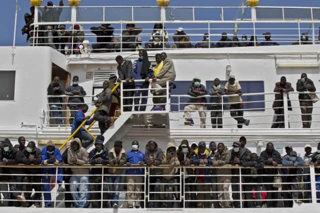 Migrants wait onboard of the 