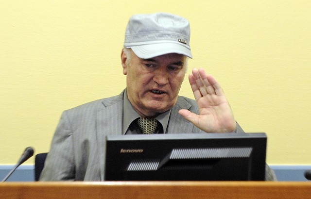 Former Bosnian Serb General Ratko Mladic salutes in the court room during his initial appearance at the U.N.'s Yugoslav war crimes tribunal in The Hague, Netherlands, Friday, June 3, 2011.Mladic's appearance Friday at the Yugoslav war crimes tribunal in The Hague is his first public appearance since he went into hiding nearly 16 years ago, when he was indicted for genocide and war crimes committed in the 1992-95 Bosnian war. (AP Photo/Martin Meissner, Pool)
