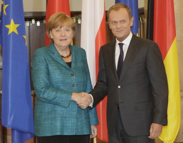 German Chancellor Angela Merkel, left, and Poland's Prime Minister Donald Tusk, right, shaking hands before presiding joint government talks in Warsaw, Poland, on Tuesday, June 21, 2011 to mark 20 years of the cooperation treaty between the neighbors that have a troubled past. They are to discuss EU upcoming budget and bailout for Greece. Poland takes the rotating EU presidency on July 1. (AP Photo/Czarek Sokolowski)