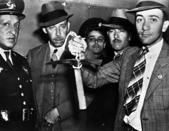 Mexican police officers are seen on August 28, 1940 examining the short-handled ice pick used to kill Leon Trotsky, the former Bolshevist Leader, when the latter was assassinated by him in his home. (AP Photo)