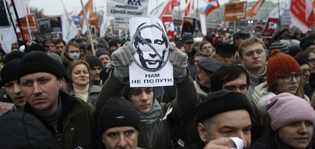 A protester holds a portrait of Putin with the words read as we are going different ways during a mass rally to protest against alleged vote rigging in Russia's parliamentary elections in Moscow, Russia, Saturday, Dec. 10, 2011. Russians angered by allegedly fraudulent parliamentary elections are protesting Saturday in cities from the freezing Pacific Coast to the southwest of Russia, eight time zones away, a striking show of indignation, challenging Prime Minister Vladimir Putin's hold on power. ( AP Photo/Mikhail Metzel) =@=
