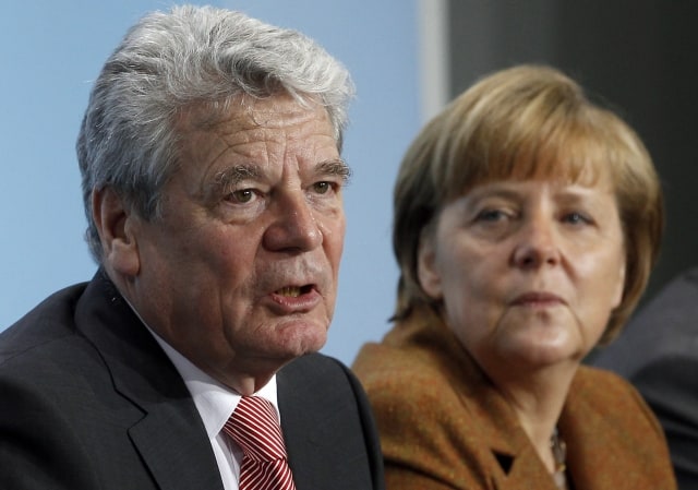 German Chancellor Angela Merkel, right, and the Theologian and designated German President Joachim Gauck, left, address the media during a joint press conference at the chancellery in Berlin, Germany, Sunday, Feb. 19, 2012. (AP Photo/Michael Sohn) =@=